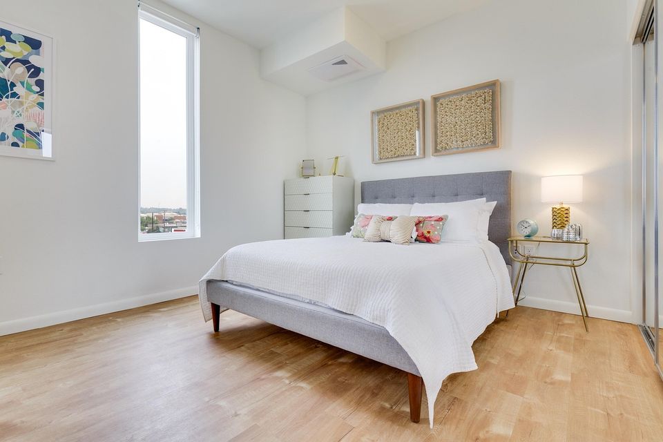 Bedroom with light neutral walls, framed art and oak floors