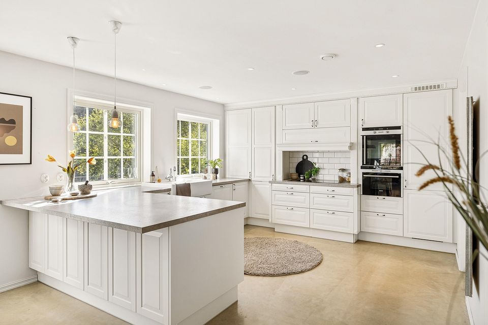 Open white kitchen with an island and living area